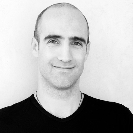 Black and White Headshot of Ed Hines smiling and wearing a black T Shirt.