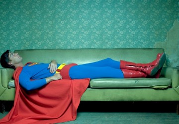 Superman laying down on a green couch