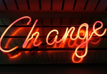 photograph of an orange neon sign reading change