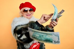 Older Lady with large sunglasses gleefully counting dollar bills
