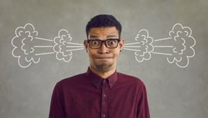 Black Man wearing glasses, grimacing with steam clouds coming out of his ears