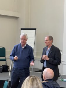 Robert Dilts and Stephen Gilligan standing in fron of a group of delegates